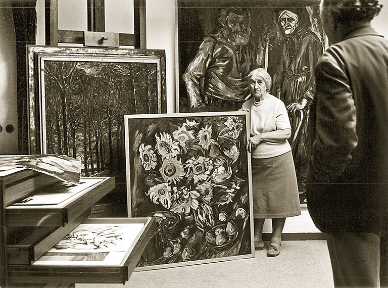 Hanna Böckstiegel, die mit ihren Kindern das Werk ihres Mannes nach seinem Tod gepflegt und der Öffentlichkeit zugänglich gemacht hat, zeigt einem Besucher im „Neuen Atelier“ des Böckstiegel-Hauses Gemälde aus dem Nachlass des Künstlers